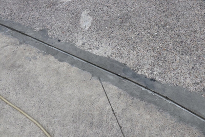 Beschädigte Dehnungsfuge in einer Beton-Bodenplatte